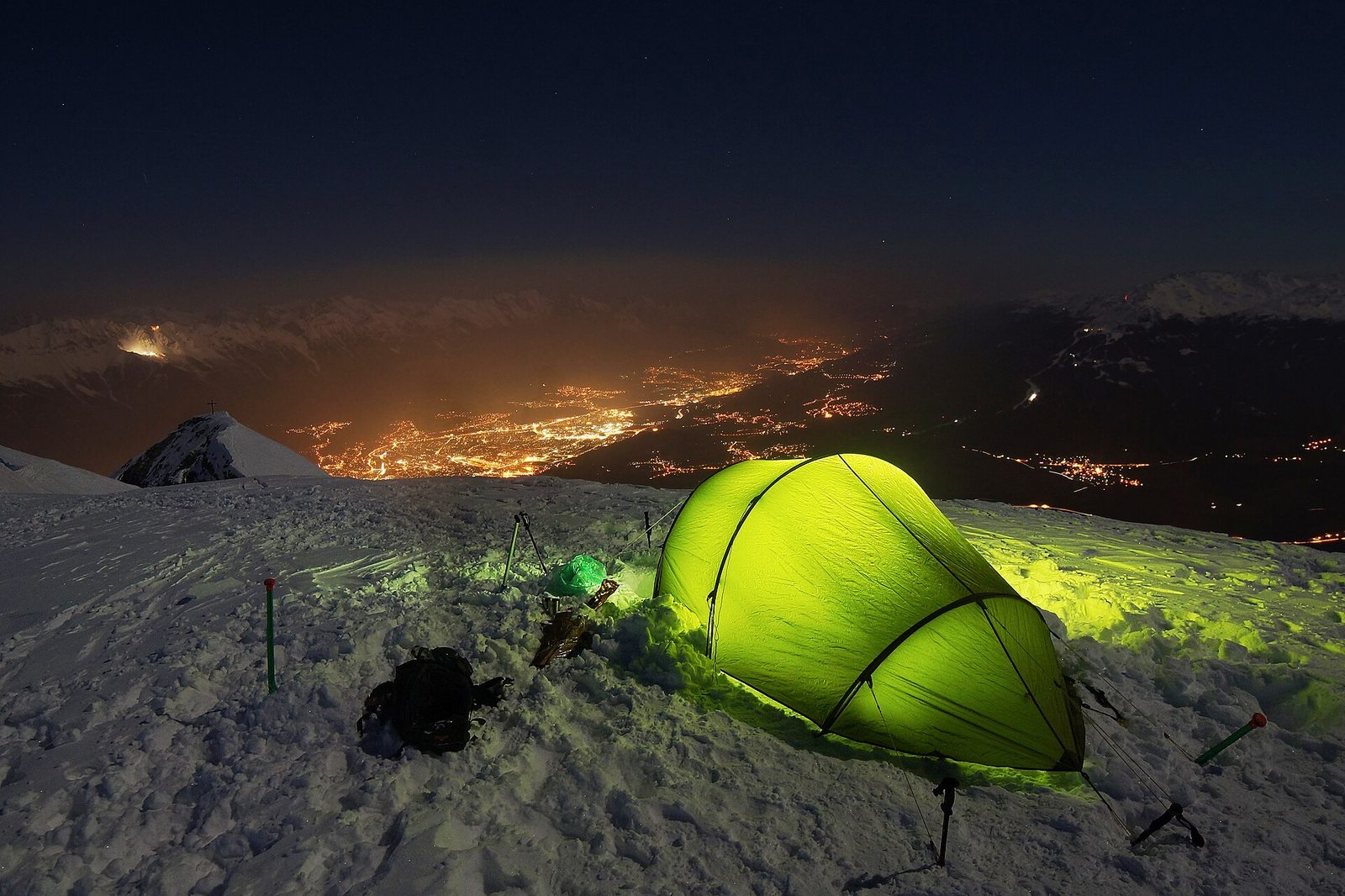 Tent glowing at a mountain base camp at dusk